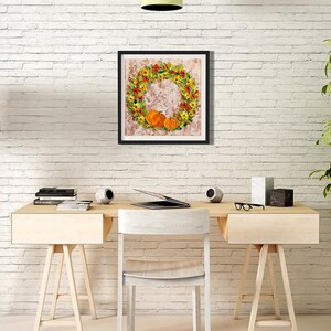 May include: A framed print of a fall-themed wreath with orange pumpkins and yellow flowers on a white brick wall background.
