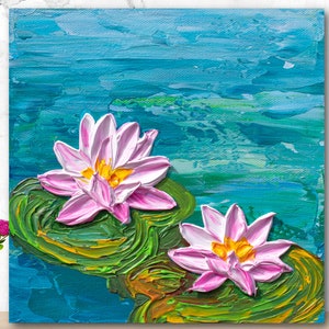 May include: A painting of two pink water lilies with yellow centers on green lily pads. The lilies are floating on a blue and green water background.