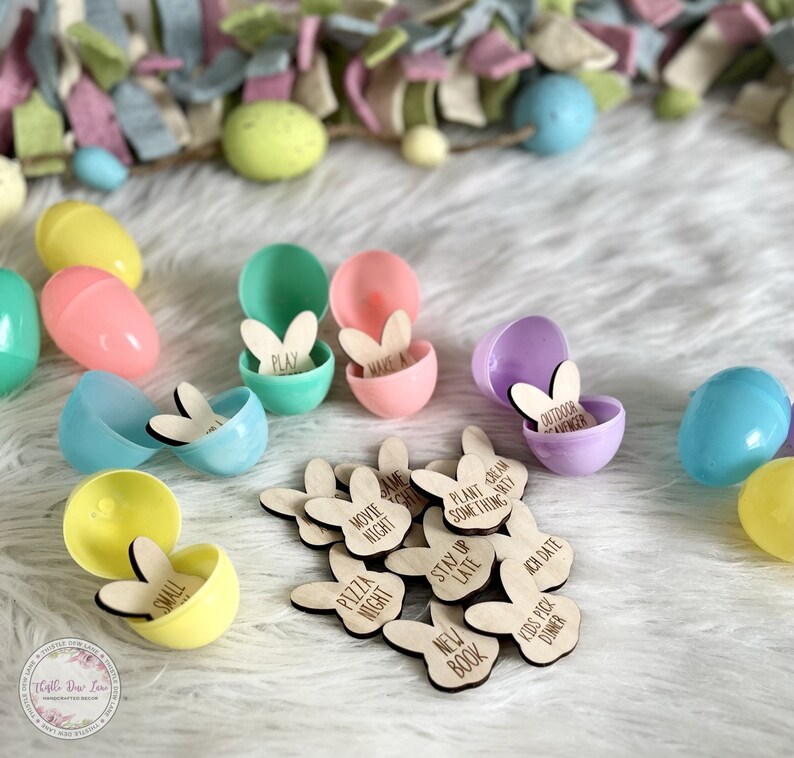 K&ouml;nnte beinhalten: Ein Set mit Oster-Eier-Aktivit&auml;ten f&uuml;r Kinder. Die Eier sind aus Plastik und in verschiedenen Farben erh&auml;ltlich. Jedes Ei enth&auml;lt ein h&ouml;lzernes Hasenohr mit einer anderen Aktivit&auml;t darauf geschrieben. Die Aktivit&auml;ten umfassen "Spielen", "Machen Sie ein", "Filmabend", "Pizzaabend", "Neues Buch", "Sp&auml;t aufbleiben", "Pflanzen Sie etwas K&uuml;nstlerisches", "Kinder w&auml;hlen das Abendessen", "Abenteuer im Freien" und "Date Night".
