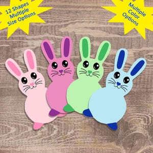 May include: Four paper bunny cutouts in different colors: pink, green, blue, and light pink. Each bunny has a simple, cartoon-like face with black eyes, a pink nose, and whiskers.