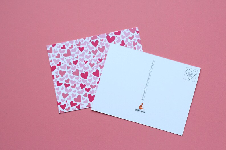 May include: A blank postcard with a pink heart pattern on the front and a white back with a small heart in the upper right corner. The back also has the text "Love, Phil" in the lower right corner.