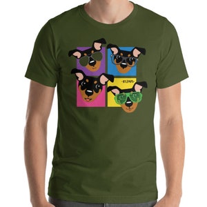Op de afbeelding: Een groen T-shirt met een afbeelding van vier honden die een zonnebril dragen. De honden zijn in popart-stijl met verschillende gekleurde achtergronden. De tekst "BIZMPS" is op het shirt gedrukt.