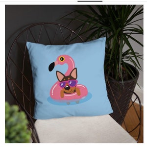 May include: A blue throw pillow with a cartoon illustration of a dog wearing sunglasses and floating on a pink flamingo pool float.