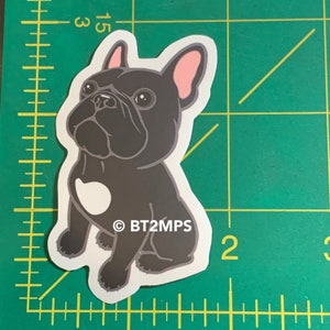 May include: A black and white cartoon French bulldog sticker with pink ears. The sticker has the text "&copy; BT2MPS" on the bottom.