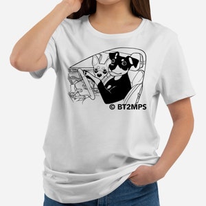Op de afbeelding: Wit T-shirt met een zwart-witte illustratie van twee honden die een auto besturen. De tekst "© BT2MPS" staat onder de illustratie.