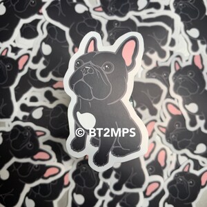 May include: A black and white sticker featuring a cartoon French Bulldog with a white patch on its chest. The sticker has the text "BT2MPS" in white letters on the bottom.