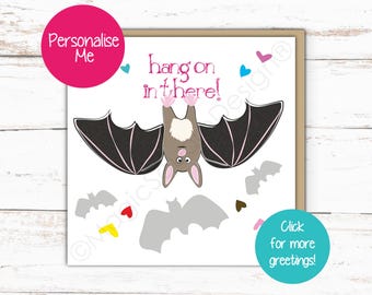 May include: A square greeting card featuring a cartoon bat hanging upside down with the text hang on in there! in pink. The design includes small colorful hearts and grey bat silhouettes scattered across a white background on the card face.