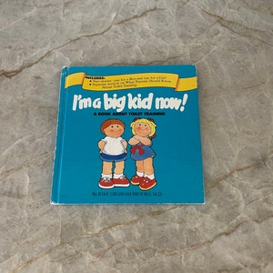 May include: A blue book titled "I'ma big kid now!" with a subtitle "A book about toilet training". The cover features illustrations of two children, a boy and a girl, standing side-by-side. The book is by Joae Graham Brooks, M.D.