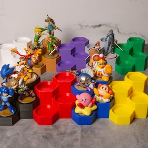 May include: A multi-level hexagonal display stand with various colorful figurines, including a blue and red robot, a yellow and red fox, a pink and yellow star, and a blue and white hedgehog. The stand is made of plastic and has a honeycomb design.