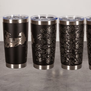May include: Four black stainless steel tumblers with clear lids, each featuring a silver laser-engraved design. Two tumblers display the Final Fantasy X logo, while the other two feature a repeating geometric pattern of interconnected circles and lines.