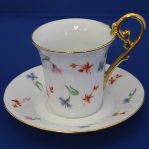Hand painted porcelain, coffee cup and saucer, floral design, with gold embellishments.