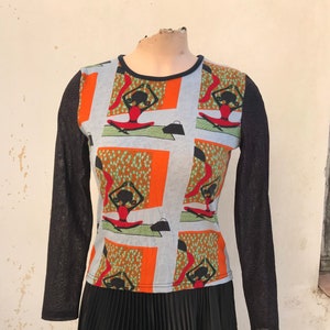 90s top features cartoon figures of girls doing yoga and sheer black long sleeves, decorated with sparkling purple polka dots