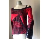Red- black 90s top featuring abstract geometric pattern, cold shoulder, sequined neckline and cuffs.