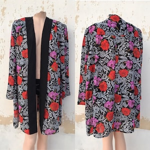 Può includere: Un kimono a maniche lunghe, trasparente con stampa floreale e bordatura nera. Il kimono ha un collo a V e una vestibilità rilassata.