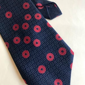 Textured polka dot 70s trevira wide, groovy necktie features red polka dot designs on dark blue canvas