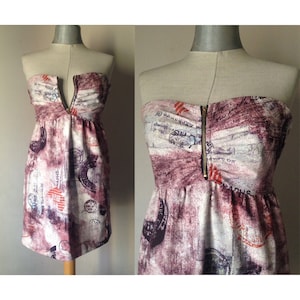 Vestido de verano súper fresco sin tirantes, totalmente de algodón, con cremallera frontal en rosa palo, marrón y un poco de violeta, con sellos y letras.
