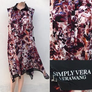 May include: Sleeveless dress with a black collar and a floral pattern in shades of burgundy, purple, and white. The dress has a black hem and the brand name "SIMPLY VERA VERA WANG" is visible.