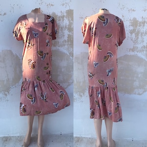 Salmon pink 80s vintage dress with pleated mermaid finishing, side buttoned and short sleeves. Sea shells prints
