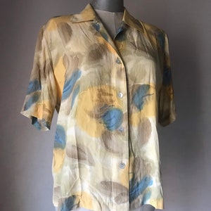 Watercolored printed 80s buttoned shirt with shoulder pads in yellow/blue pal hints forms abstract designs. M-L size