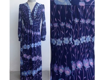 Hermoso vestido largo de principios de los años 70 con estampado floral azul y morado que presenta escote en V, mangas abullonadas, falda acampanada y cintura imperio.