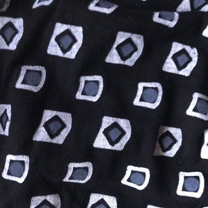 May include: Black fabric with a repeating pattern of white squares containing grey diamonds.
