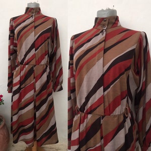 May include: A long-sleeved dress with a high collar and a brown, red, and gray striped pattern. The dress has a cinched waist and a flowing skirt.