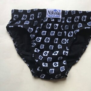 May include: Black underwear with a white geometric pattern. The underwear has a label that reads "Nikolas 100% Cotton Made in Greece".
