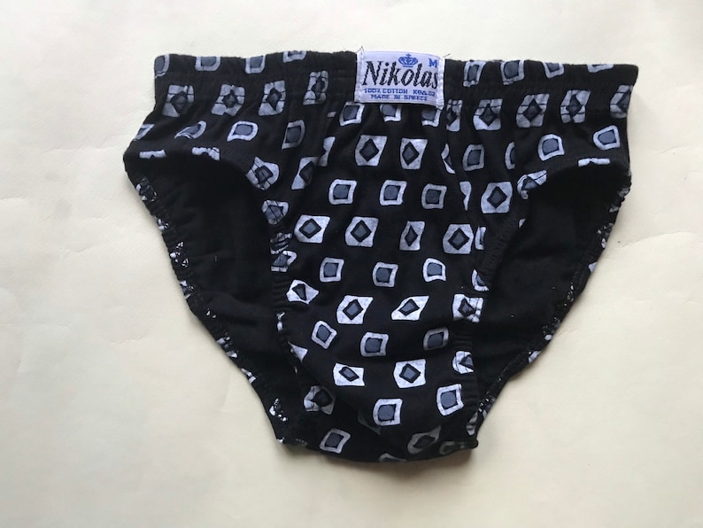 May include: Black underwear with a white geometric pattern. The underwear has a label that reads "Nikolas 100% Cotton Made in Greece".