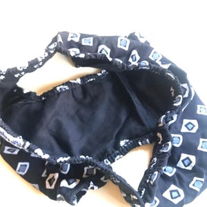 May include: Black underwear with a white and blue geometric pattern. The underwear is made of a soft, stretchy fabric.