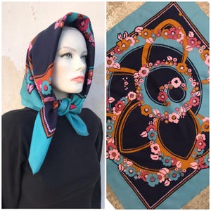 70s squared scarf featuring retro print of swirling flowers in pink, brown surrounded by a turquoise frame. Impressive!