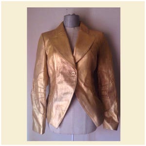 Veste cintrée en cuir doré métallisé, coupe frac qui se ferme par un bouton sur le devant, vintage des années 90