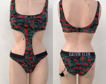 Calvin Klein einteiliger Badeanzug mit speziellen Ausschnitten und exotischen Blumendrucken in dunkelgrün und rot. Logo-Details, 00s Vintage