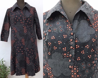 70s cool buttoned down shirtdress with rad pointed collars, pleated skirt and orange tiny flower prints on black/gray  background