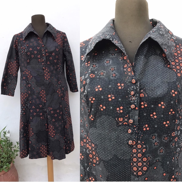 70er Jahre cooles Hemdblusenkleid mit spitzem Kragen, Faltenrock und orangen kleinen Blümchen auf schwarz/grauem Hintergrund
