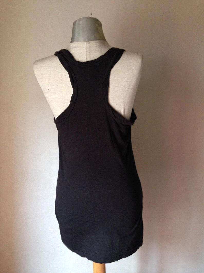 Op de afbeelding: Een zwart tanktop zonder mouwen met een racerback-ontwerp. Het tanktop is gemaakt van een zachte, rekbare stof.