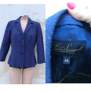 May include: A blue blazer with a fitted silhouette and a single button closure. The blazer has a label that reads "Luisa Spagnoli" and "44".