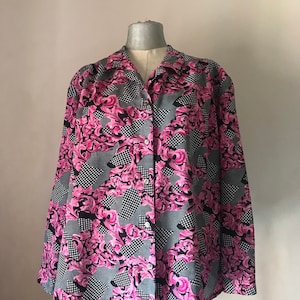 Könnte beinhalten: Ein langärmliges Hemd mit Knöpfen und einem geometrischen Muster in Pink, Schwarz und Grau. Das Hemd hat einen Kragen und eine lockere Passform.