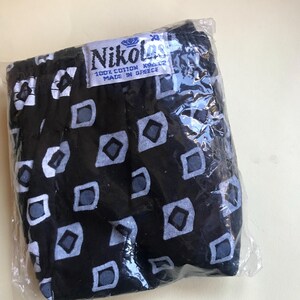 May include: Black underwear with a white and grey geometric pattern. The underwear is packaged in a clear plastic bag and has a label that reads "Nikolas 100% Cotton Made in Greece".