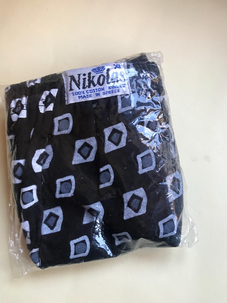 May include: Black underwear with a white and grey geometric pattern. The underwear is packaged in a clear plastic bag and has a label that reads "Nikolas 100% Cotton Made in Greece".