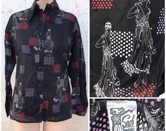 Blusa vintage de los años 70 con botones y cuellos puntiagudos, de estilo Art Déco, en color negro con detalles en rojo, morado y crudo.
