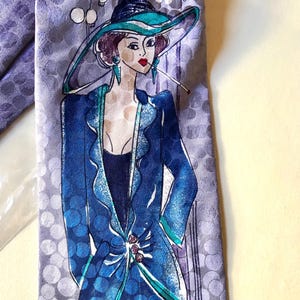 Könnte beinhalten: Eine Vintage-Krawatte mit einer stilisierten Illustration einer Frau in blauem Outfit und Hut, die eine Zigarette raucht. Die Krawatte hat einen lavendelfarbenen Hintergrund mit weißen Punkten und das Wort "BAR" oben.