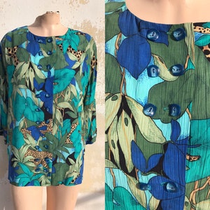 以下が含まれることがあります： ボタン留めの青い、緑色の、そして茶色の模様のブラウス。模様は葉、花、そして動物柄です。