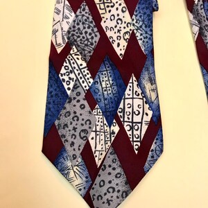 May include: A burgundy, blue and grey patterned tie with a geometric diamond design.