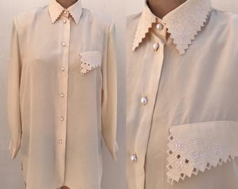 Chemisier boutonné vintage beige crème du début des années 90 avec cols festonnés/surpiqués, épaulettes, boutons nacrés