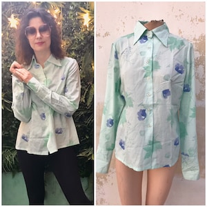 Mint green 70s shirt features blue/mauve anemones and plane leaves prints. Pointed collared 70s vintage buttoned blouse in light mint green