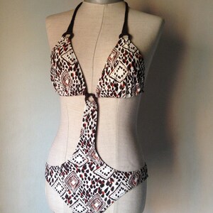 70s style one piece swimsuit with rings, special cut outs & open back in brown coloring feat animal prints mixed with wax, African patterns