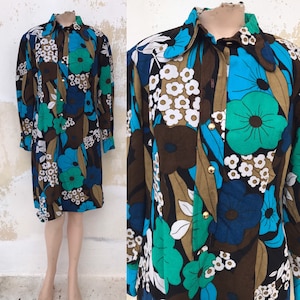 Könnte beinhalten: Ein langärmeliges Kleid mit einem braunen, blauen, grünen und weißen Blumendruck. Das Kleid hat einen Kragen und einen Knopfverschluss.