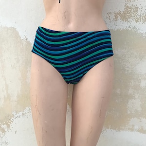 Puede incluir: Braguita de bikini de cintura alta con rayas horizontales en tonos azules y verdes. El traje de baño se exhibe en un maniquí sobre un fondo neutro. La tela parece ser elástica.