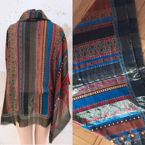 May include: A brown, blue, and red patterned scarf with geometric designs. The scarf is made of a soft, lightweight fabric and has a fringed edge.