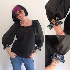 Schwarze, lockere Bluse im Carmen-Stil mit Puffärmeln und gerafften Blumenbündchen!
